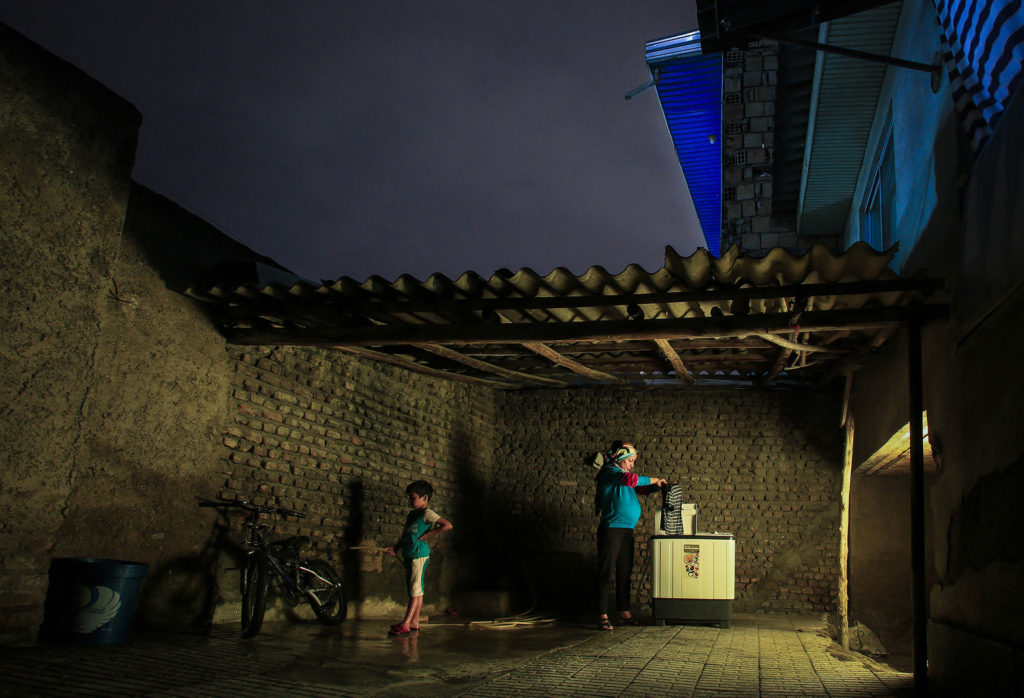 Zahra, en el séptimo mes de embarazo, hace sus tareas domésticas, como lavar la ropa de sus hijos en el patio.