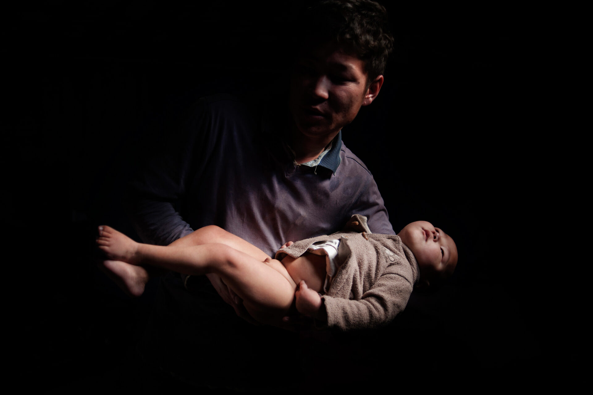 Ulan Bator, Mongolia, Asia. Gambatatar Baatarch, 28 años, antiguo pastor, en su tienda (gher) con su hijo. Solía vivir con su mujer en la provincia del Govi Altay. Su mujer se cansó de vivir esa vida de miseria y decidió irse a buscar otro marido. Le dejó solo con su hijo, que sufre una enfermedad mental y no puede moverse.