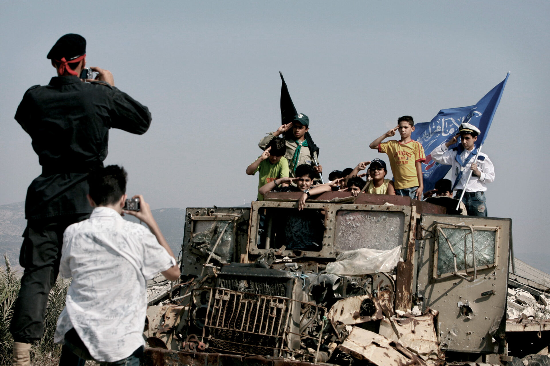 La fotografía muestra a un grupo de niños posando encima de un camión destruido por bombas del Ejército israelí, dentro de la cárcel de Kiham, situada al sur del Líbano. Un miliciano de Hizbulá les fotografía después de enseñarles las instalaciones completamente destruidas y de explicarles cómo los soldados israelíes torturaban a los presos islámicos.