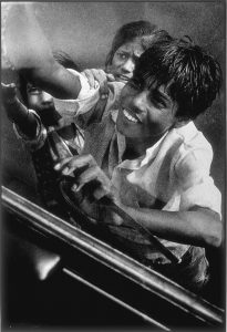 Fotografía tomada en Katmandú ayudando a unos niños con unas rupias desde un autocar.