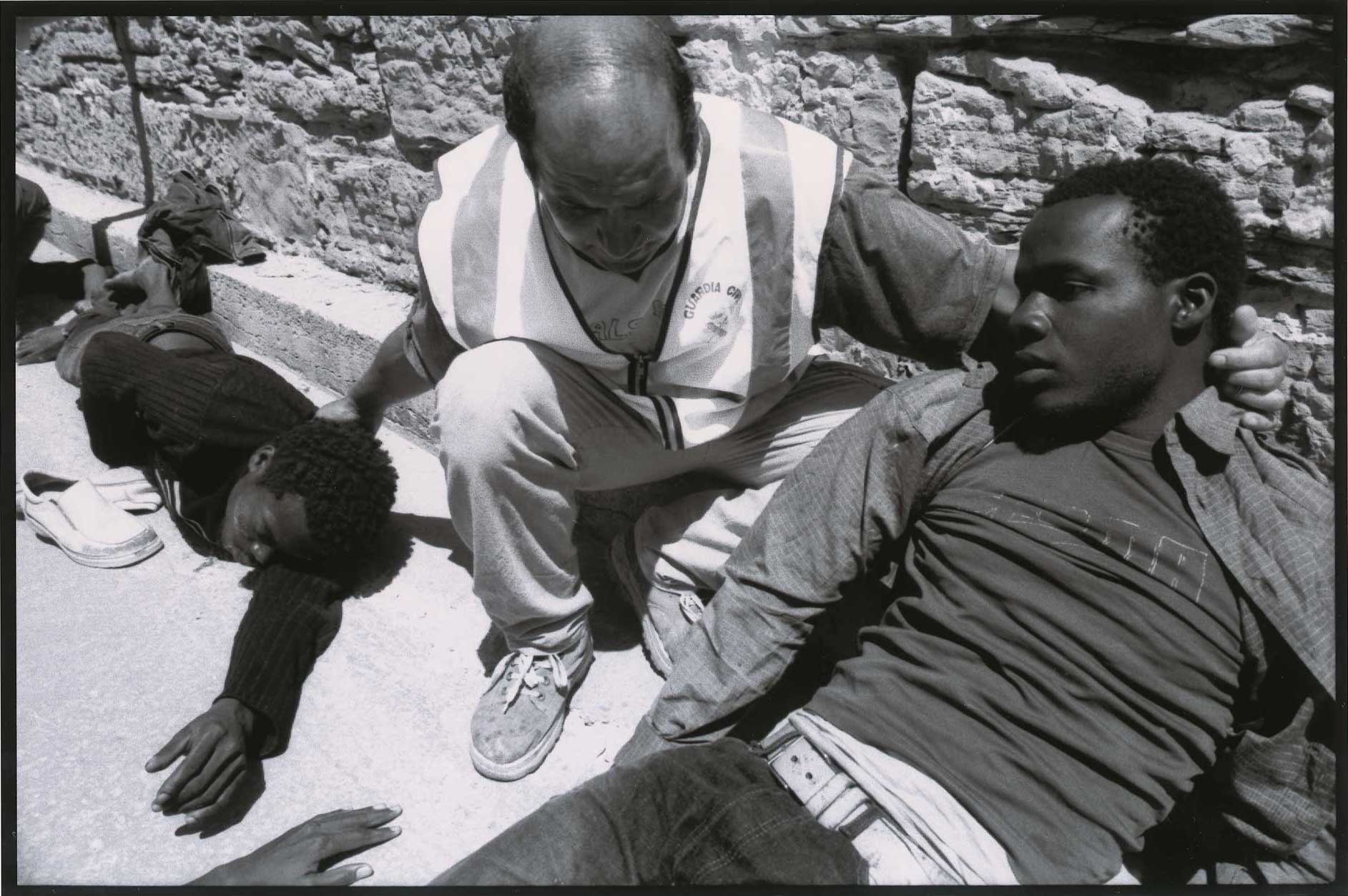 Un Guardia Civil socorre a migrantes en Tarifa, Cádiz, durante el verano de 2003. Se calcula que unas 15.000 personas perdieron la vida en el Estrecho de Gibraltar entre 1993 y 2003. Aunque son muchos los que consiguen llegar, también es ingente el número de personas muertas en el mar. Algunos de los cuerpos encontrados en las playas fueron enterrados en los cementerios de la zona bajo la leyenda “inmigrante anónimo”.