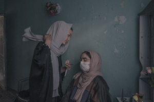 En un taller clandestino de Kabul, mujeres asisten a clases secretas de maquillaje. En 2023, los talibanes ordenaron el cierre de todos los salones de belleza del país, alegando que ofrecían servicios prohibidos por el Islam y que generaban dificultades económicas para las familias de los novios durante las bodas. Junto con limitar el empleo femenino y su acceso a espacios públicos como parques y gimnasios, los talibanes también han impuesto fuertes restricciones a la libertad de prensa. Como consecuencia, millones de adolescentes permanecen fuera de la escuela, y las universidades han sido declaradas inaccesibles para mujeres. Las asistentes a este taller esperan que algún día puedan trabajar públicamente otra vez o iniciar negocios secretos de belleza. Algunas jóvenes ya han comenzado a abrir sus propios salones clandestinos.