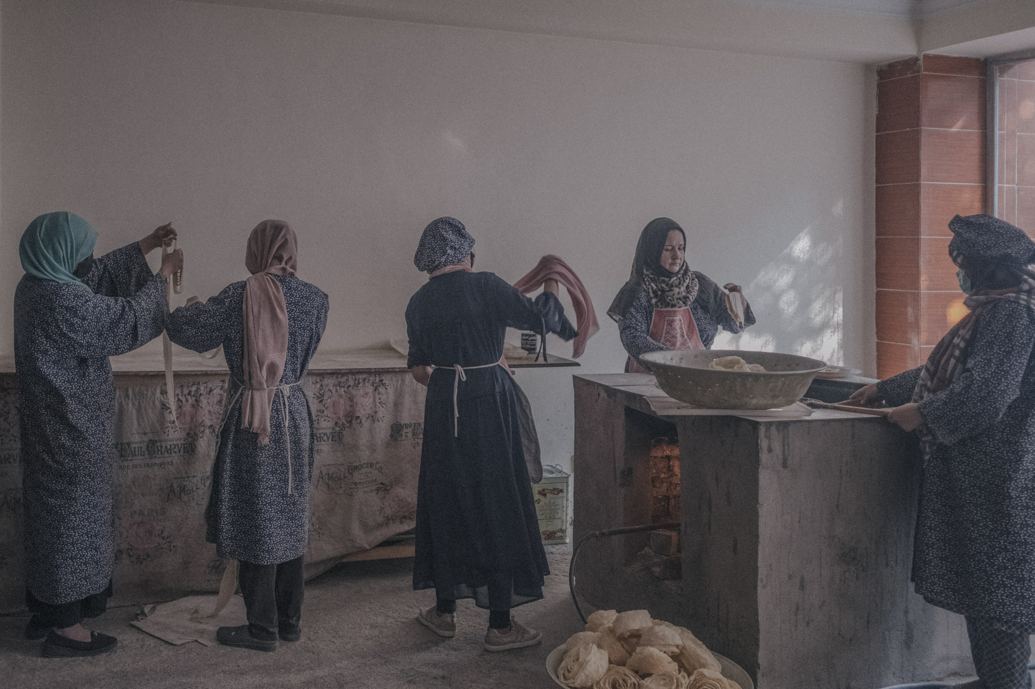 Un grupo de mujeres trabaja en un taller tradicional de repostería en Kabul. La propietaria cuenta que al iniciar el negocio tenía 25 empleadas. Tras el regreso de los talibanes y el deterioro económico, se vio obligada a despedir a la mitad, ya que no podía pagar sus salarios. Invirtió todos sus ahorros en este emprendimiento y, en un comienzo, empleó hombres para ayudar en la elaboración y decoración de pasteles para ocasiones especiales. Sin embargo, las nuevas reglas talibanes que prohíben que hombres y mujeres trabajen juntos hicieron imposible continuar, y la propietaria no contaba con los recursos para abrir un espacio separado para trabajadores varones.